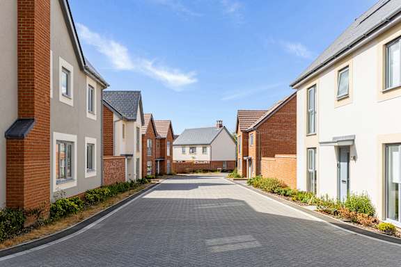 A row of houses with a driveway in the middle.