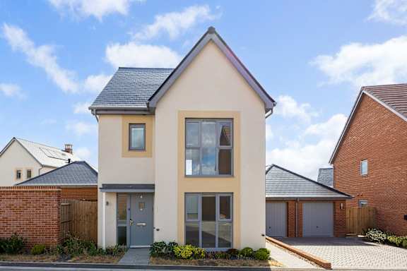 A modern house with a grey front door and a large window.