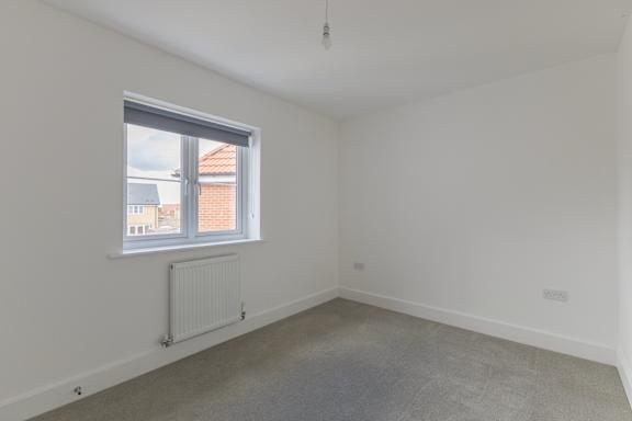 A room with a window and a radiator on the wall.