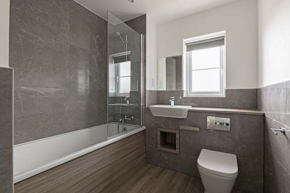 A modern bathroom with a walk-in shower and a toilet.