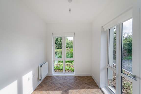 A room with a window and a view of a garden outside.