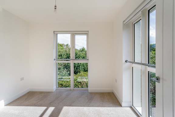 A room with a large window and sliding glass doors.