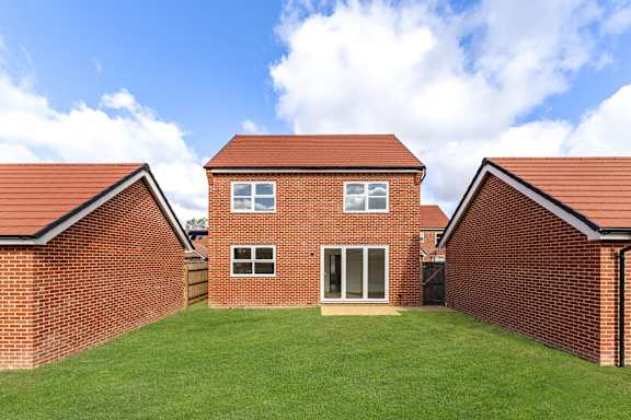 A red brick house with a green lawn in front.