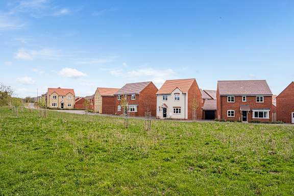 A row of houses with green grass in front.