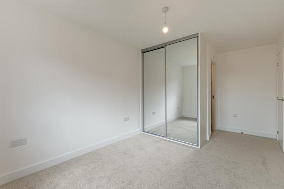A room with a carpeted floor and a glass door.