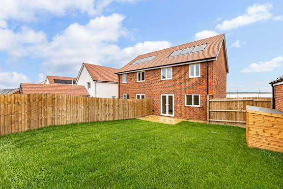 A house with a brown fence and a green lawn.
