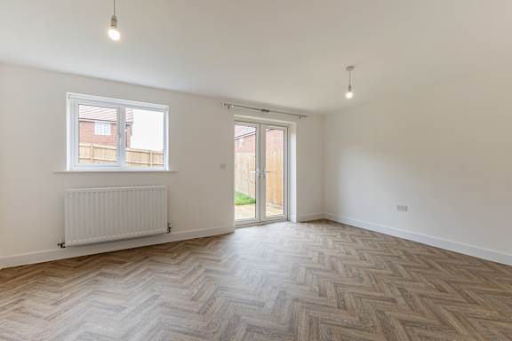 A room with a herringbone patterned floor and a window.