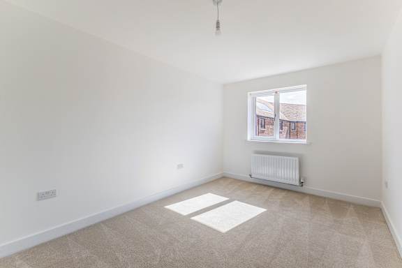 A room with a window and a radiator on the floor.