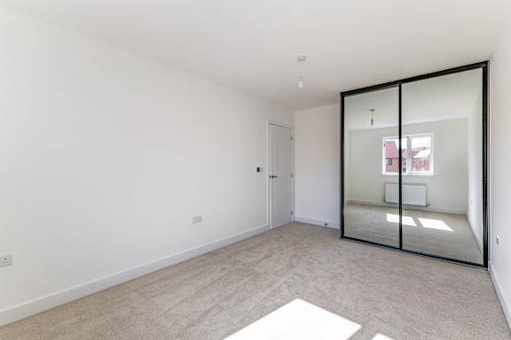 A room with a white wall and a glass door.