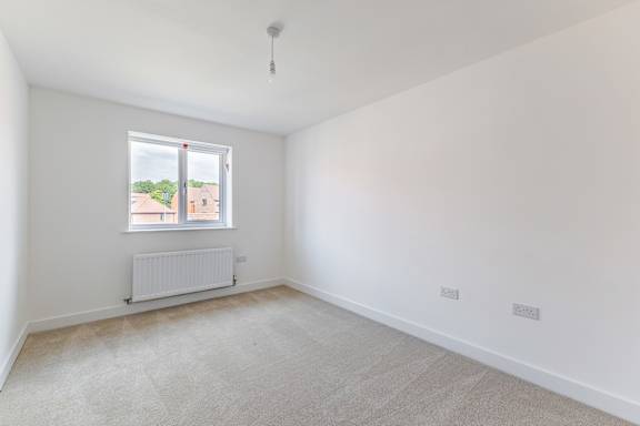 A room with a window and a radiator on the wall.