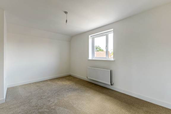 A room with a window and a radiator on the wall.