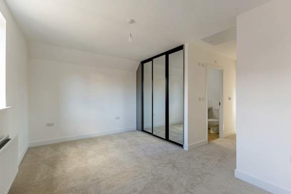 A room with a carpeted floor and a glass door.