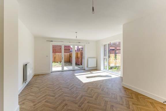 A room with a wooden floor and white walls.