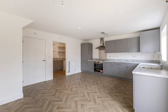A kitchen with a herringbone patterned floor.