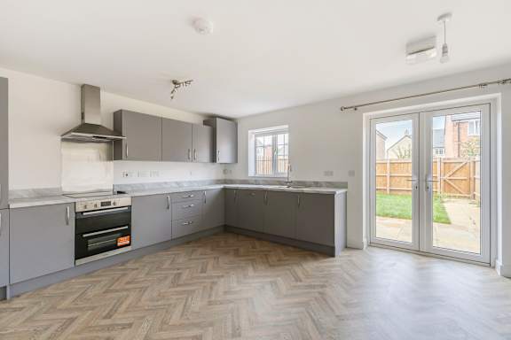 A kitchen with a stove top oven and a range hood.