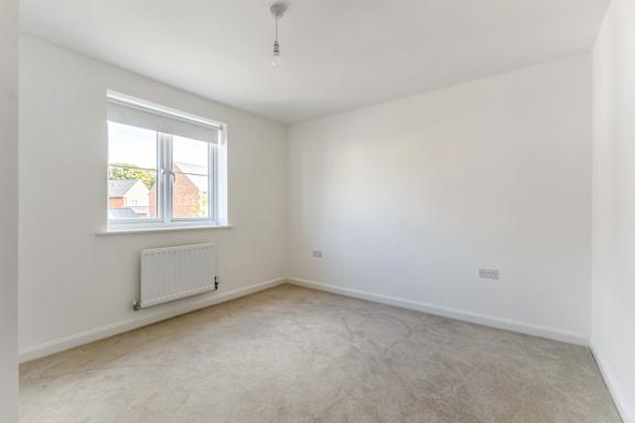 A room with a window and a radiator on the wall.