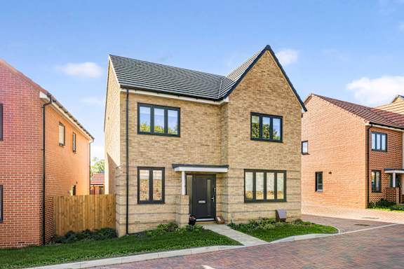 A modern house with a brick facade and a black door.