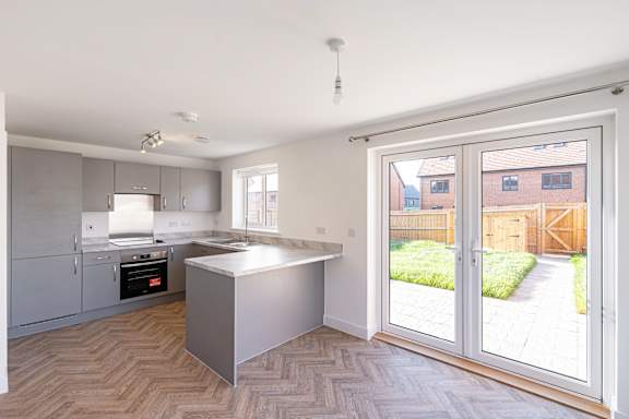 A kitchen with a white counter top and a window.