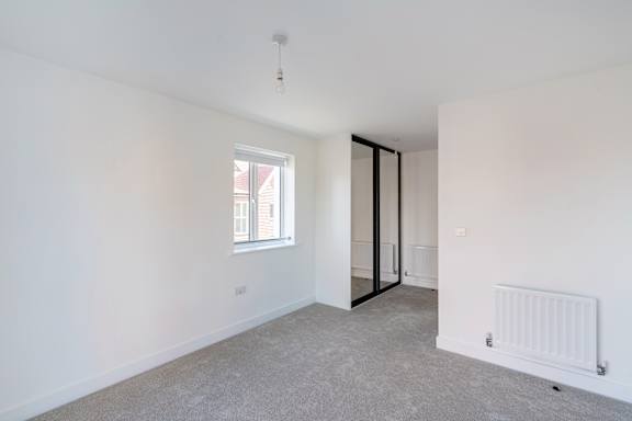 A room with a window and a door leading to another room.