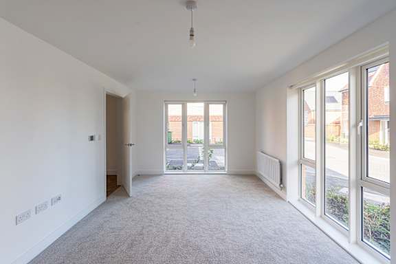 A spacious room with a door leading to a balcony.
