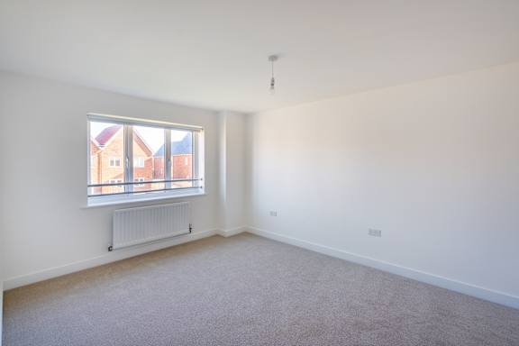 A room with a window and a radiator on the wall.