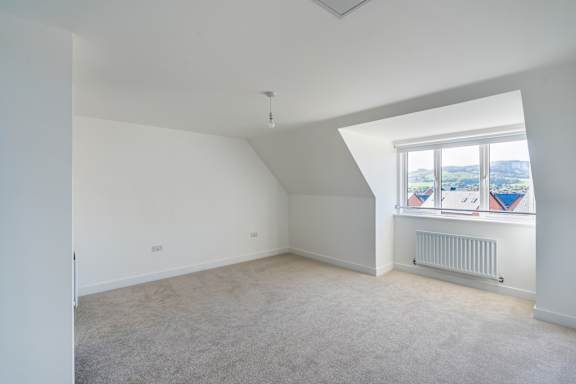 A room with a window and a radiator on the wall.