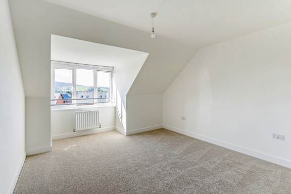 A room with a window and a radiator on the wall.