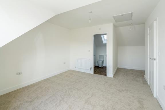 A room with a carpeted floor and a skylight.