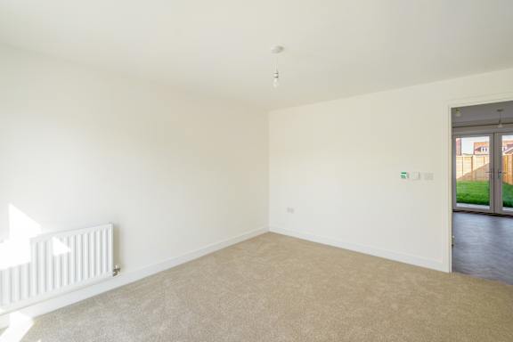A white room with a radiator and a door leading outside.