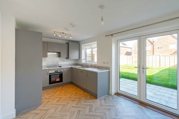 A modern kitchen with a large island and a view of the backyard.