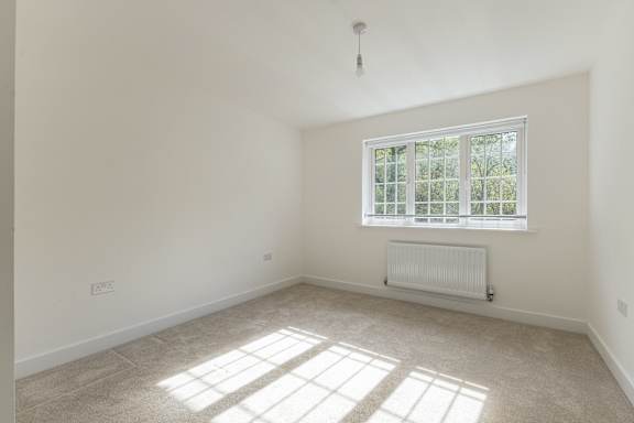 A room with a window and a radiator on the floor.