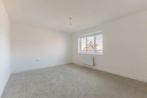 A room with a window and a radiator on the wall.