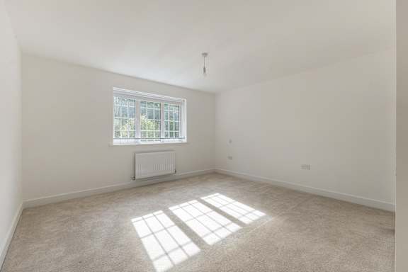 A room with a window and a radiator on the floor.