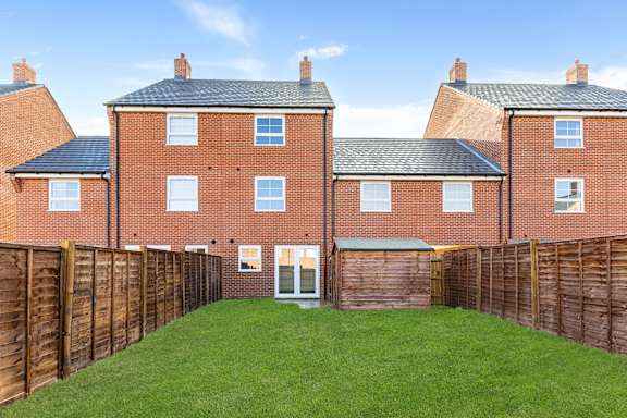A red brick house with a green lawn in front.