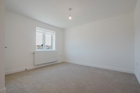 A room with a window and a radiator on the wall.
