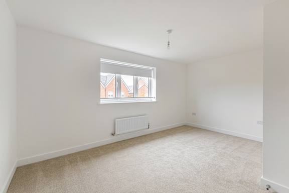 A room with a window and a radiator on the floor.
