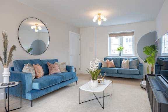 A living room with a blue couch and a white coffee table.