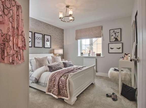 A bedroom with a large bed and a pink blanket.