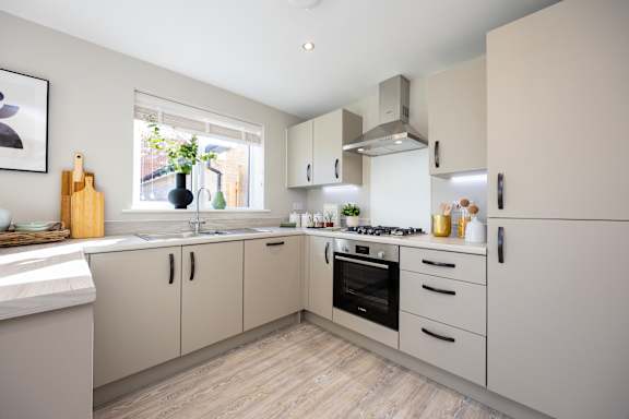 A modern kitchen with a wooden floor and white walls.