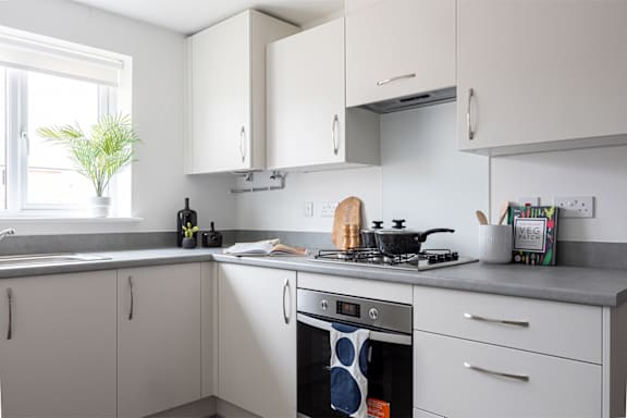 A modern kitchen with white cabinets and a grey countertop.