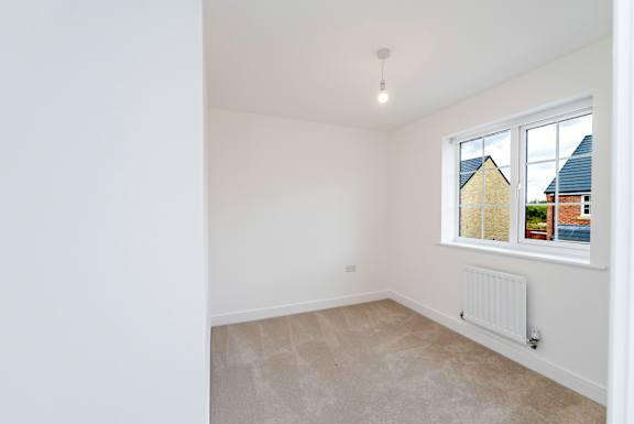 A room with a window and a radiator on the wall.