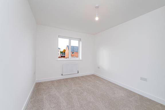 A room with a window and a radiator on the floor.