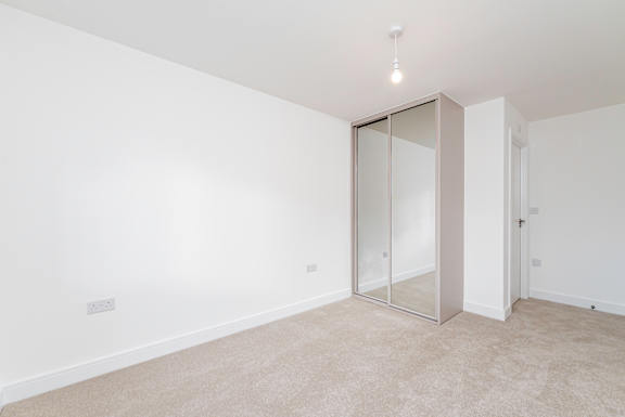 A room with a carpeted floor and a sliding door.