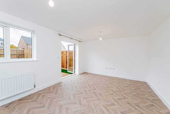 A room with a herringbone patterned floor and white walls.
