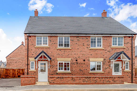 A brick house with a white door and windows.
