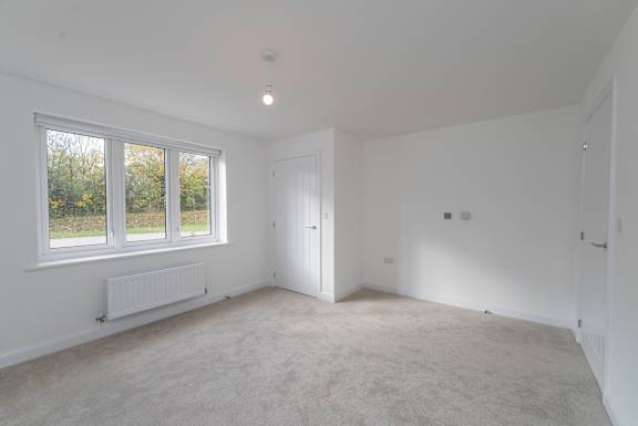 A room with white walls and carpeted floor.
