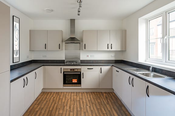 A kitchen with white cabinets and a black countertop.