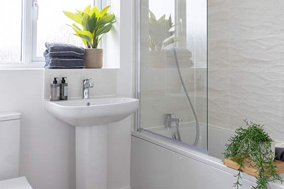 A white bathroom with a sink, toilet, and bathtub.