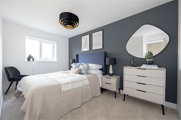 A bedroom with a bed, nightstand, and chair.