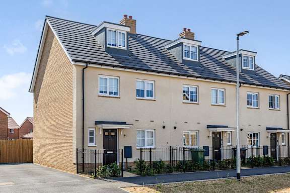 A row of houses with a black fence in front.